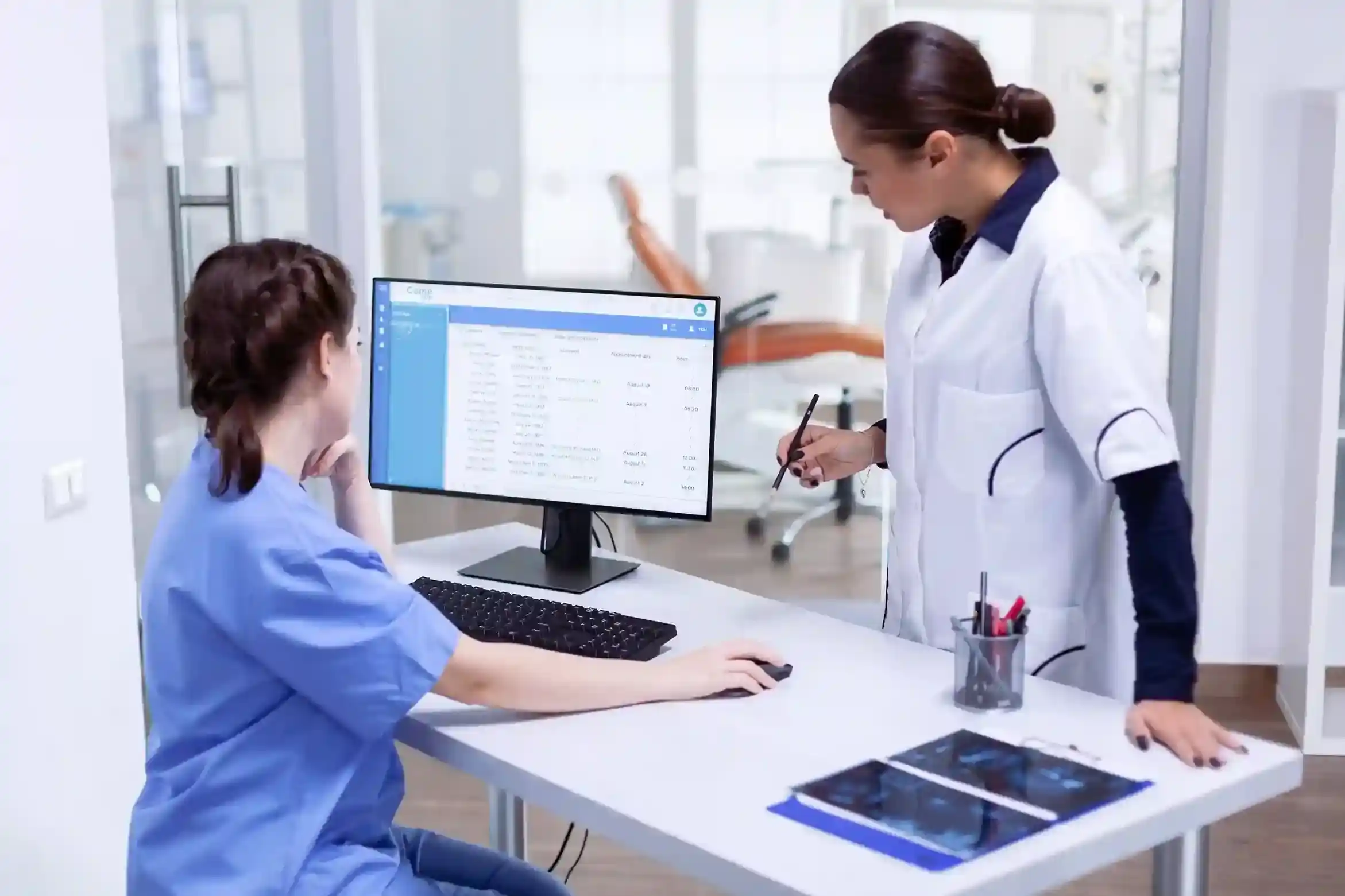 Medical professionals using computer systems in a clinic setting, illustrating specialized software solutions for healthcare-industries.